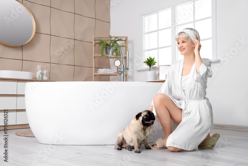 Young woman with pug dog in...