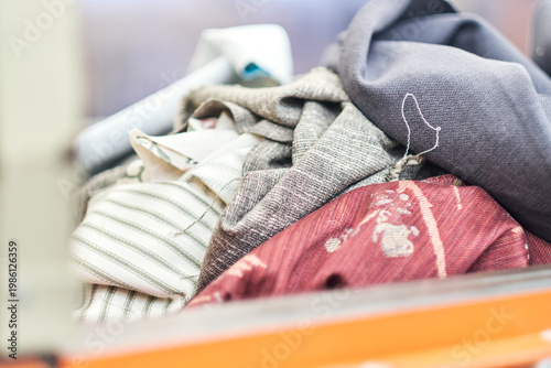 mixed fabric offcuts and textile waste from industrial bin for recycling and reuse. Industrial recycling programme aimed to cut costs and be better for the environment.