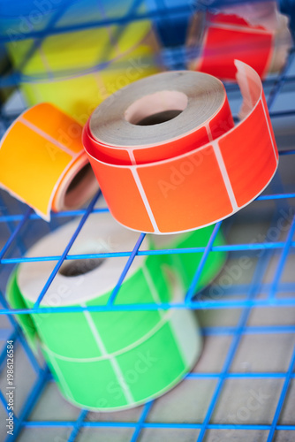 Bright coloured Illuminous adhesive label rolls on an industrial production line in packaging and manufacturing environment. Food labels for health safety and hygiene purposes.