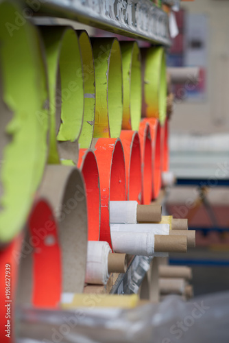 rows of material cardboard rolls and cardboard cores stored on industrial rack in textile and manufacturing workspace. Fabric and manufacturing textile storage.