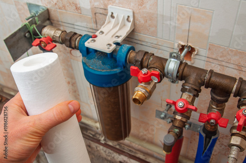 Photos Replacing a dirty water filter cartridge in a household filtration system