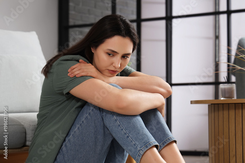 Depressed young woman sitti...