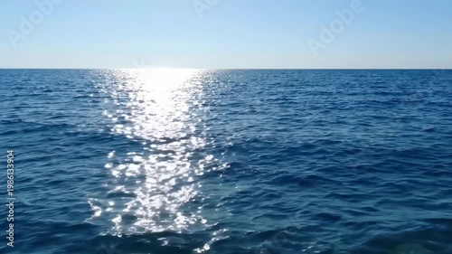 Tranquil Sea with Sunlight Reflection on a Calm Blue Ocean Surface