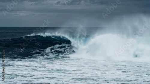Serene Ocean Wave Crashing on Shore with Clouds and Misty Horizon Landscape