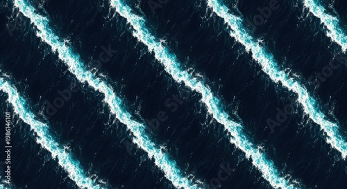 Aerial view of ocean waves with white and blue water patterns on dark surface