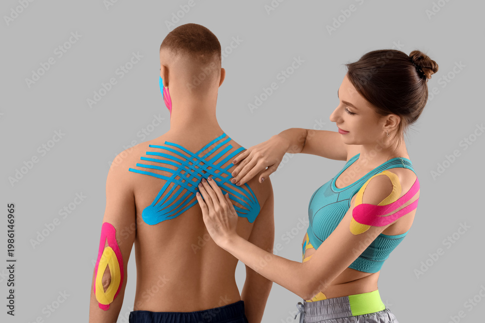 Obraz premium Young couple with physio tape on grey background