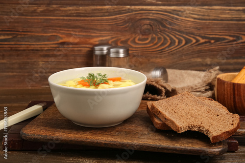 Принти на полотні Bowl of tasty chicken soup and bread on wooden background