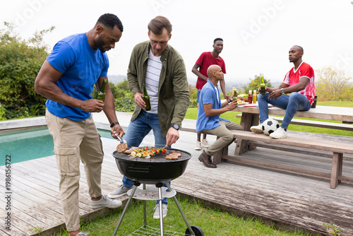Schilderij op canvas Backyard barbecue sparking diverse male friends grilling on charcoal grill by po