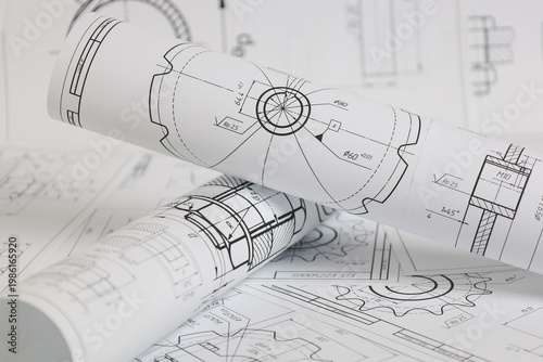 paper engineering drawings of industrial parts and mechanisms