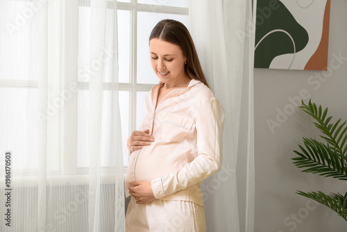 Young pregnant woman in paj...