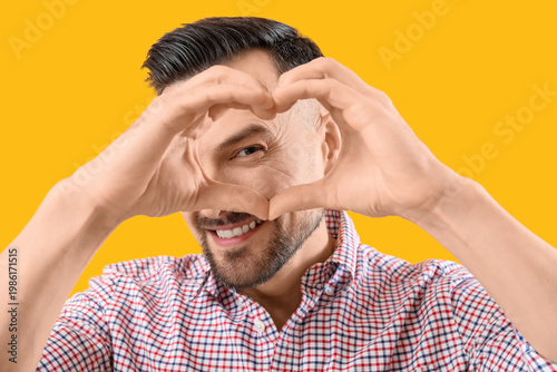 Handsome man making heart w...