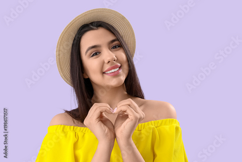 Young woman making heart wi...