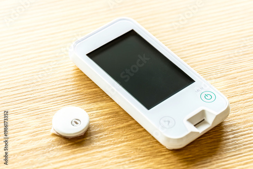 Close up of glucometer and glucose sensor showing capillary fingerstick and interstitial measurement methods