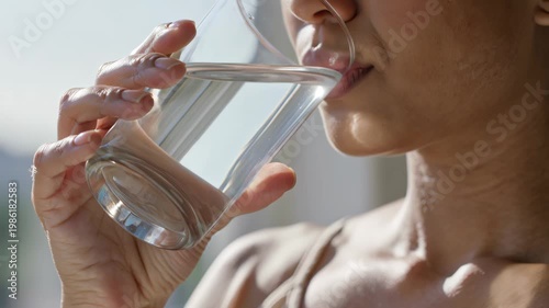 Woman holding a glass of clear water in her hand up close