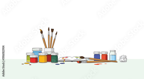 A collection of vibrant paint jars and artist brushes surrounds an open sketchbook on a clean white surface creating a professional creative workspace.