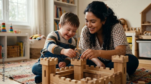 Woman with child playing with wooden castle blocks. Caring mother helping little boy with down syndrome build toy fortress. Educational early development hobby in home interior.
