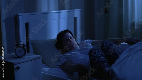 Elderly woman getting out of bed at night to use bathroom or wake early
