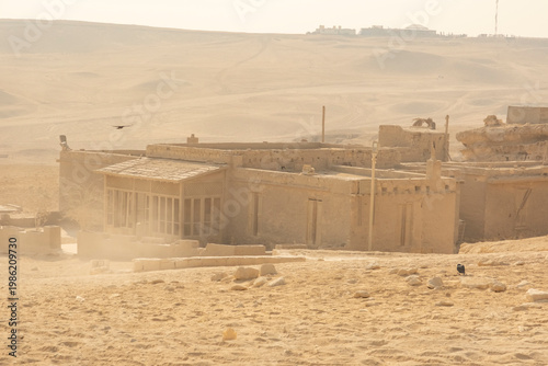 Old building in a desert landscape with sand and clear skies near ancient ruins during the daytime