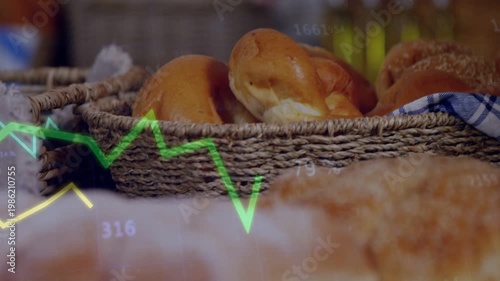 Camera moving forward, bread loaves coming into focus as green,yellow charts tracking bakery sales