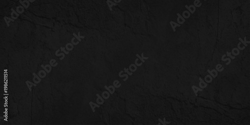 A dark grunge texture of old black paper and rough fabric material creates a vintage blank surface design for a weathered grey wallpaper backdrop