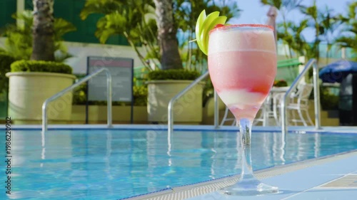 Static Close-Up of Pink Tropical Cocktail by Swimming Pool - 60fps
