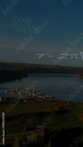 Vertical video: Ruins and marina filling frame, camera shifting down, formulas drifting for science