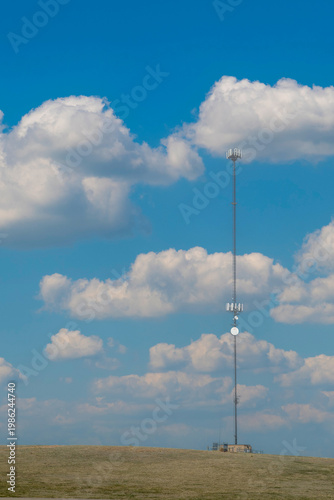 Cell Phone Tower against a cloudy blue sky
