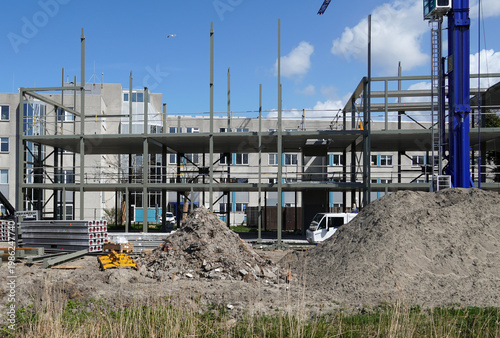 Skeleton frame, framed structure of an extension to an office building. Steel beams, crane. Dutch city of Alkmaar. Spring, April, Netherlands.