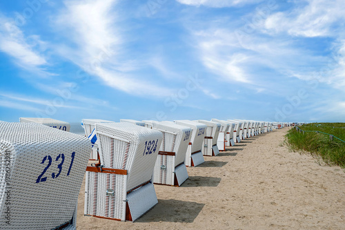 Many white beach chairs set up in a row on the beach in Büsum, Schleswig-Holstein.