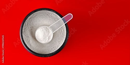 Spoon with creatine proteine in an opened can for sporty lifestyle, seen directly above. Panoramic image wirh copy space. 