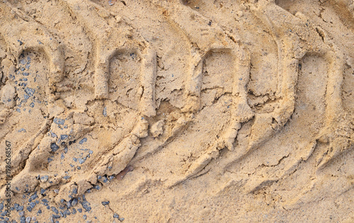 Foto Deep tractor tire tread imprinted in dry sand