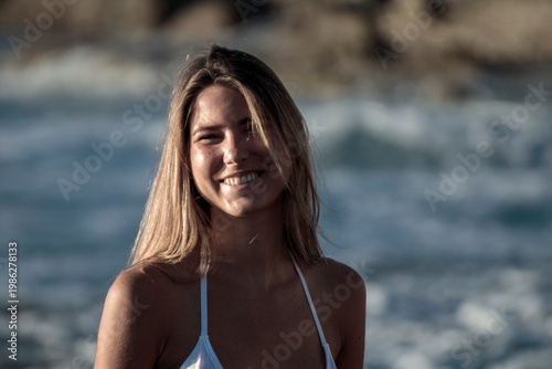 Young woman smiling enjoying beach and ocean waves