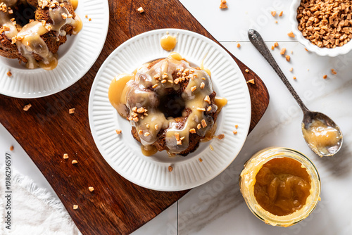 A top down view of servings of sticky toffee pudding topped with toffee bits.