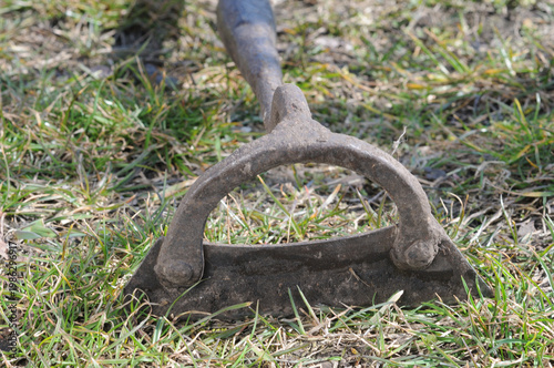 Old rusty hoe on the grass. Garden tools. Selective focus.