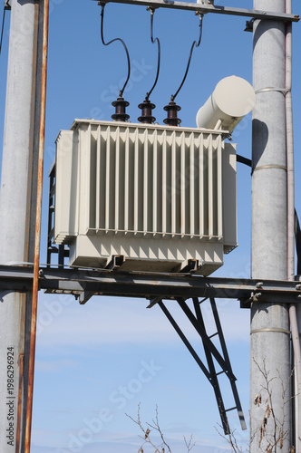 Power transformer on the background of blue sky, closeup of photo.