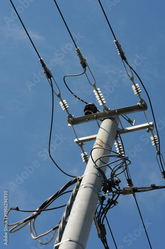 Electricity post with blue sky background, closeup of photo.