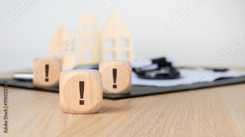 Multiple exclamation marks on blocks with blurred houses. Real estate red flags, urgent risks and inspection warning concept.