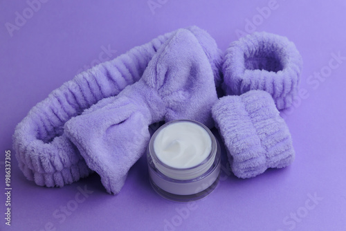 Fotografija Soft purple skincare accessories arranged on a purple background with a cream ja