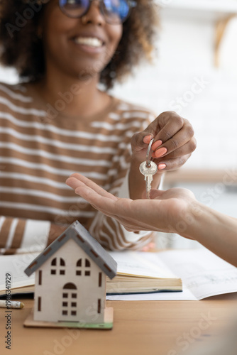 Принти на полотні Close-up of happy woman realtor or property owner handing over key to house