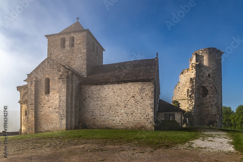 Cornil (Corrèze, Nouvelle aquitaine, France) - Vue matinale brumeuse des ruines du donjon du château de la Chapoulie et l'église de l'invention des reliques de Saint Etienne