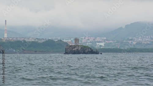 A lighthouse against a backdrop of gloomy skies and stormy weather on a cliff in Avacha Bay in the Pacific Ocean of the Kamchatka Peninsula