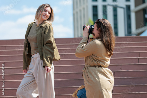 Photographer shooting model outdoors in modern city setting