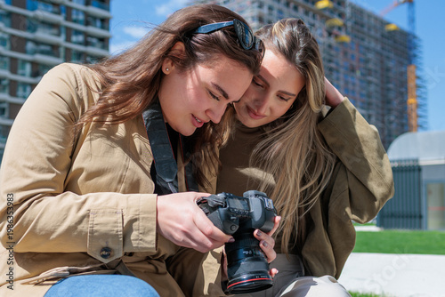 Two women reviewing photos on digital camera together
