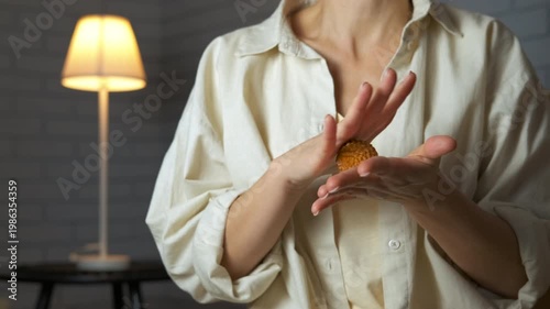 Woman massaging her hands with a spiky ball. Unrecognizable woman using a spiky massage ball for her hands and fingers, improving blood circulation and performing self-care relaxation exercises