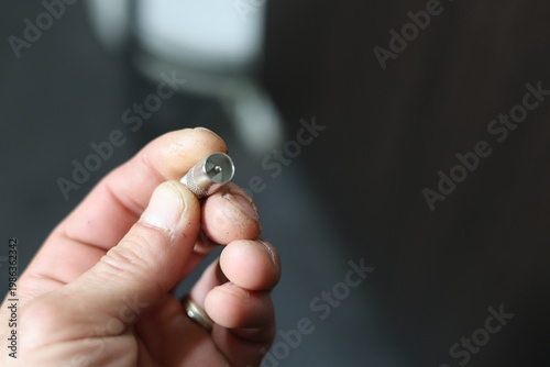 Close-up of a silver coaxial cable connector lying on a textured surface