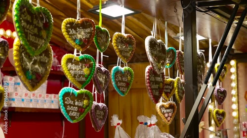 Gingerbread hearts hanging at a christmas market stall. Colorful gingerbread hearts, known as lebkuchenherzen, hanging at a festive food stall in a traditional christmas market, featuring sweet