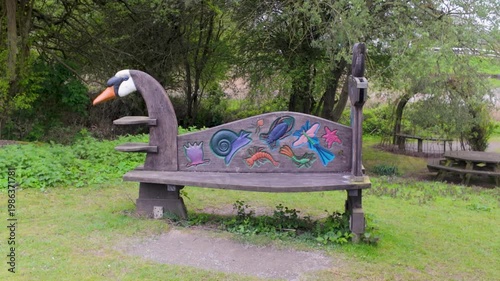 Whimsical carved bird-shaped bench in a park