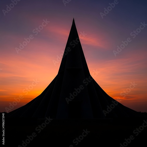 Sharply pointed monument silhouette against colorful sunset sky
