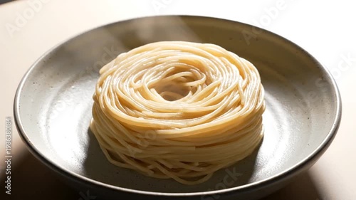 Steaming hot spaghetti pasta swirled in a bowl