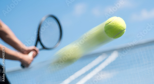 Dynamic shot of a tennis ball speeding over the net with motion blur, capturing power, speed, and intensity of outdoor match play.